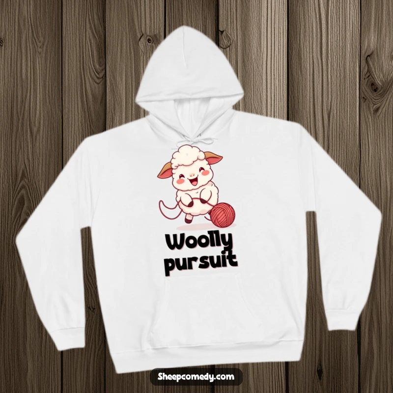 Funny sheep hoodie showing a playful character chasing a bouncing ball of yarn, emanating cheerful energy.